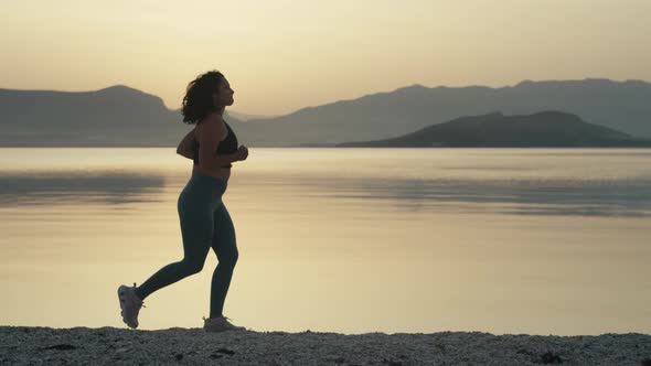 Slow Motion Video of a Girl in a Sports Suit on a Morning Jog By the Ocean alt