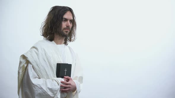 Prophet in White Robe Holding Bible, Praying to God With Humility, Devotion alt