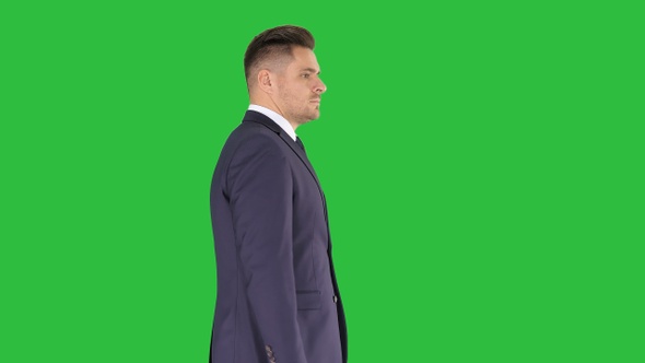 Businessman goes forward on a Green Screen, Chroma Key. alt