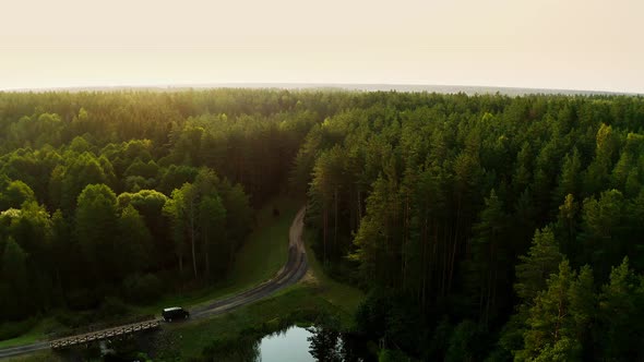 A black car, a minibus drives through a picturesque place with a lake