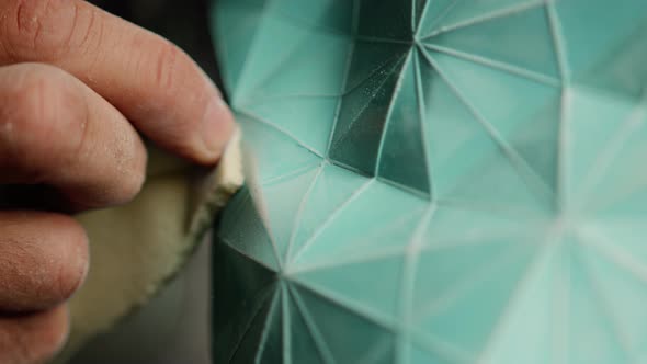 Close-up: a male artisan painter sculptor wipes the product, puts things in order in the workshop alt