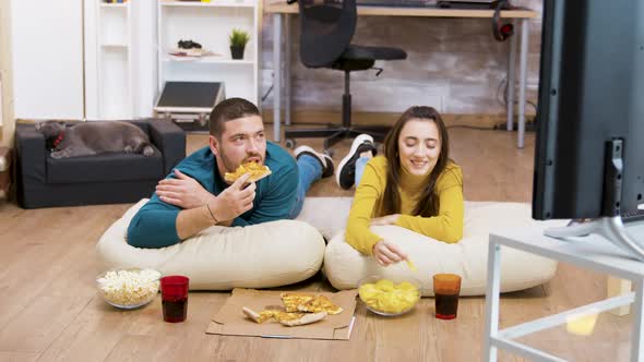 Bearded Man Drinking Soda and Sitting on Pillows for the Floor alt