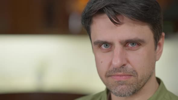 Dissatisfied Caucasian Man Looking at Camera with Angry Facial Expression Posing Indoors on the alt
