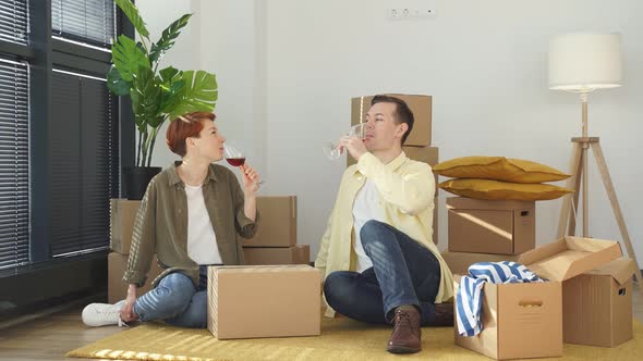 Beautiful Senior Romantic Couple in Love Sitting on Apartment Floor with Boxes Around Celebrating