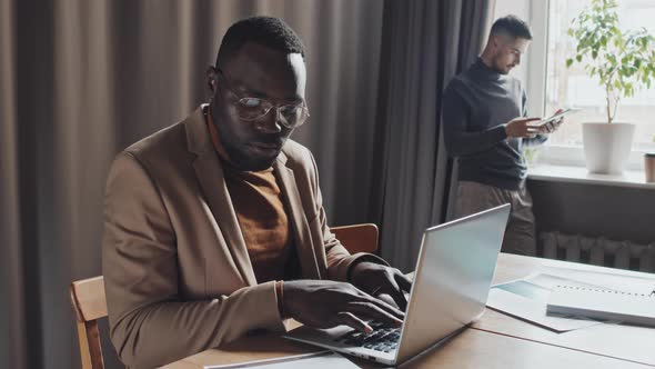 African American Businessman Typing on Laptop alt