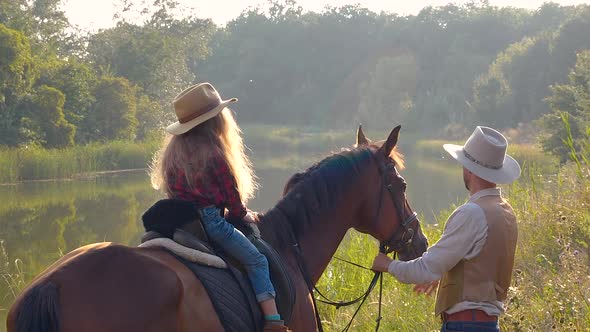 Cowboy and His Daughter on Horseback alt
