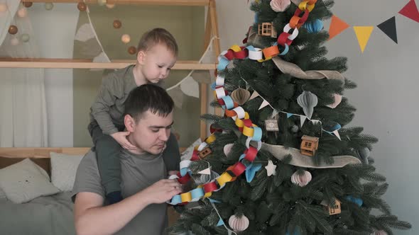 Child Boy with His Dad Decorating Christmas Tree alt