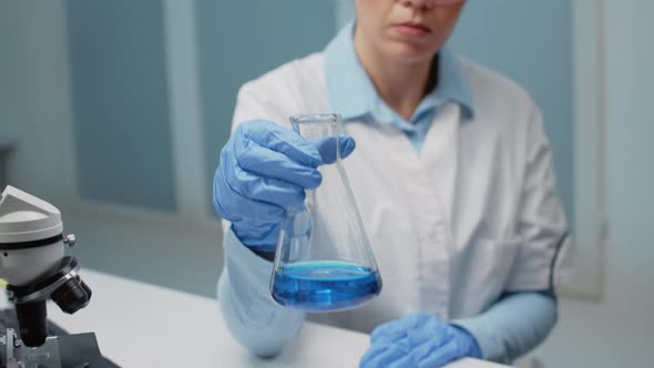 Portrait of Microbiology Doctor Analyzing Chemical Beaker alt