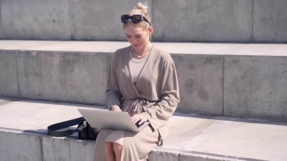 Female Freelancer Using Laptop on Street Stairs alt