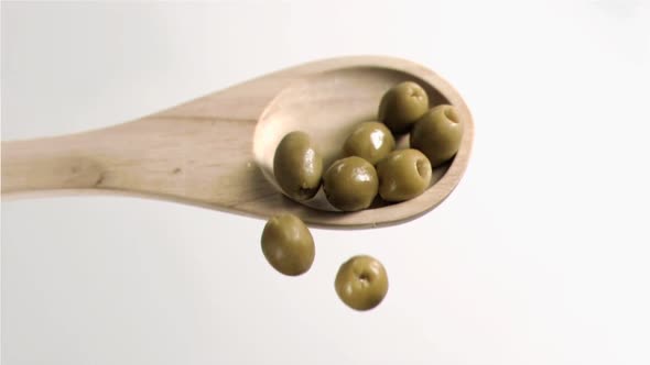 Olives falling in super slow motion from the spoon alt