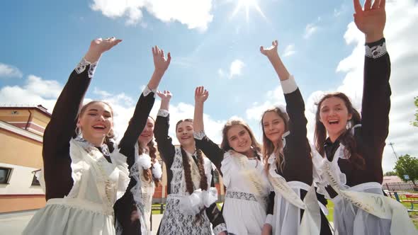 Happy Female Graduates Take Their Hands Off the Videocamera on Graduation Day alt