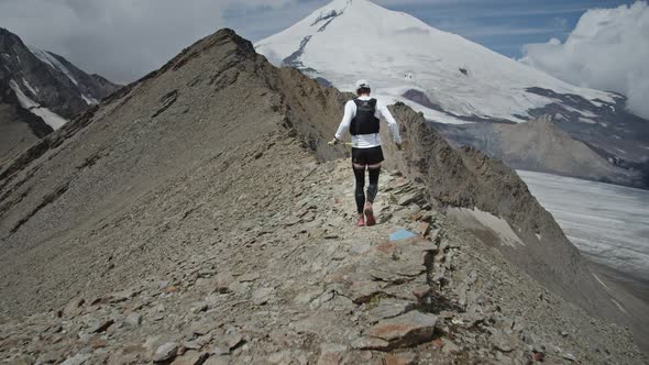 Following the Man Running on a Ridge in a Big Mountains