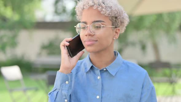 Portrait of Young African Woman Talking on Phone alt