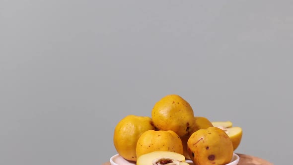Quince Fruits On A Plate. Fruit Is Yellow. The Plate Rotates On The Stage alt