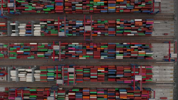 Top Down Birds Eye Aerial View of Industrial Cranes Moving Large Containers in Cargo Port alt