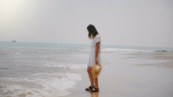 Young Beautiful Happy Caucasian Woman in Light White Summer Dress Touching Warm Waves at Idyllic alt