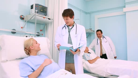 Obstetrician talking to a patient lying in a bed alt