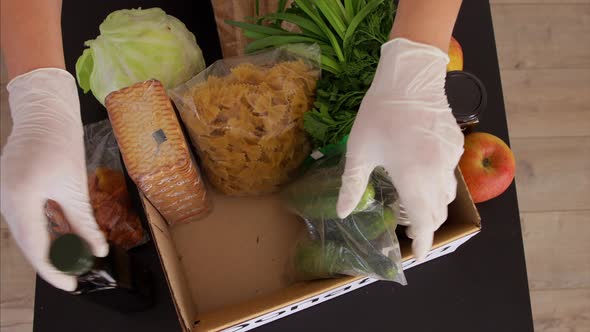 Woman in the Protective Medical Gloves Unpacking Donation Box.  Top View