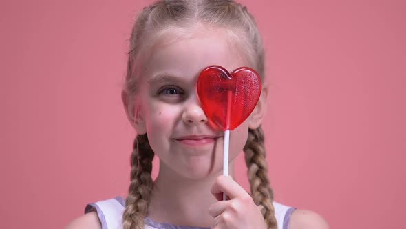 Cute Girl Having Fun, Closing Eye With Heart-Shaped Lollipop, Valentines Day alt