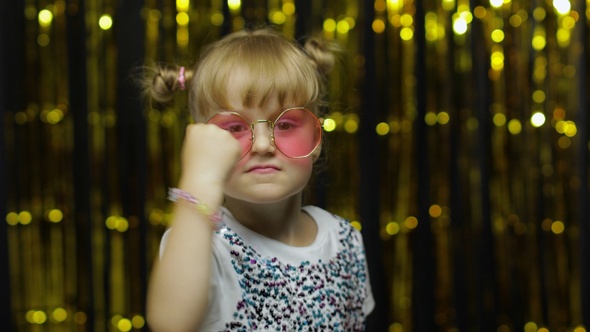 Funny Child Trying To Fight at Camera, Boxing with Expression. Girl Posing on Shiny Background alt