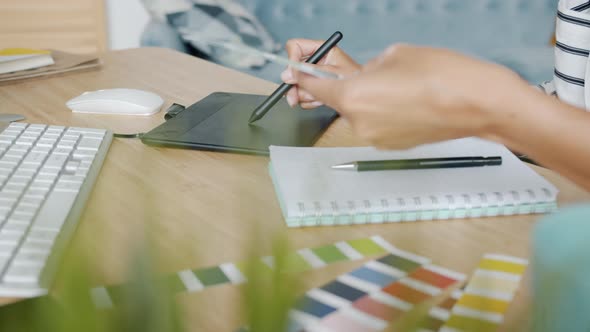 Closeup of Female Hand Using Graphics Tablet Working at Computer Table at Home alt