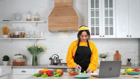 Woman Slices Cucumber Listen Teacher Chef Study Online Video Call Webcam Laptop alt