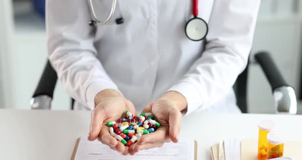 Doctor Holds Multicolored Medical Pills in Hands alt