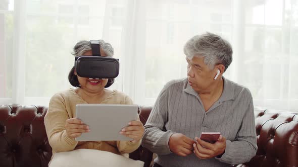 Senior woman having fun to playing game in VR glasses alt