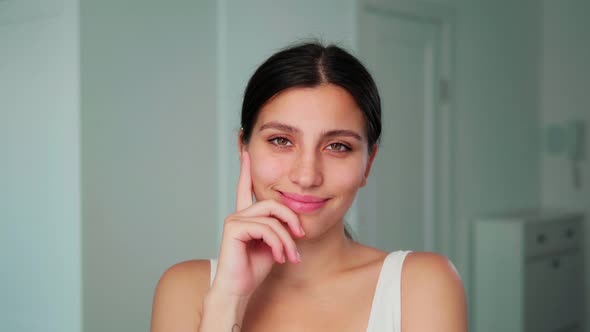 The Girl is Thinking at the Camera and Smiling