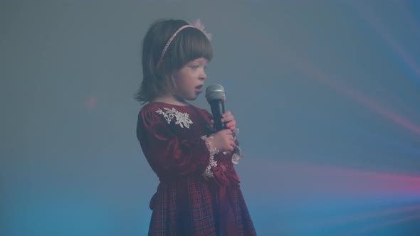 Cute Little Girl on Stage in Vintage Dress She Sings Into Microphone and Dances