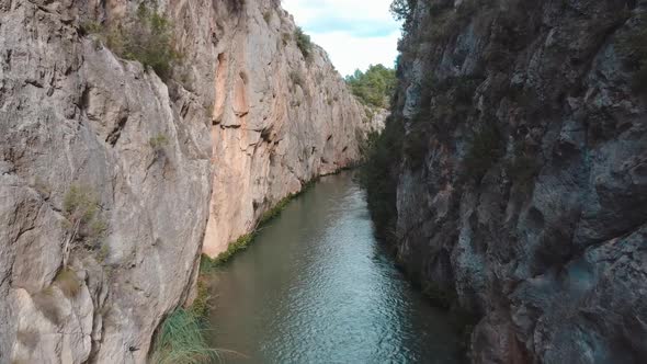 Drone flying over a river between Rocky Mountains in Valencia, Spain alt