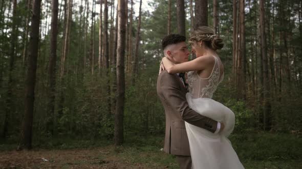 Slow Motion As the Wedding Couple Whirls in the Woods. Beautiful Young Wedding Couple alt