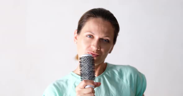 Beautiful Young Woman Sings and Holds Hairbrush As Microphone alt