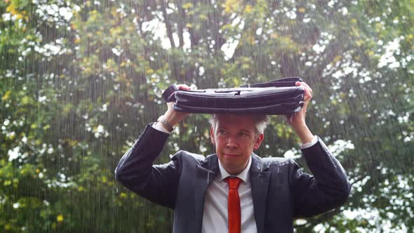 Businessman Sheltering Underneath his Bag in the Rain