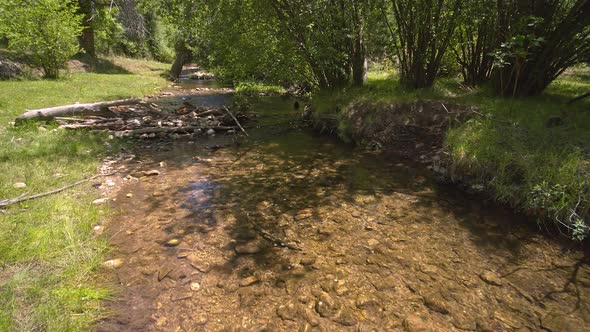 Moving up river over small creek rotating while looking down at the clear water alt