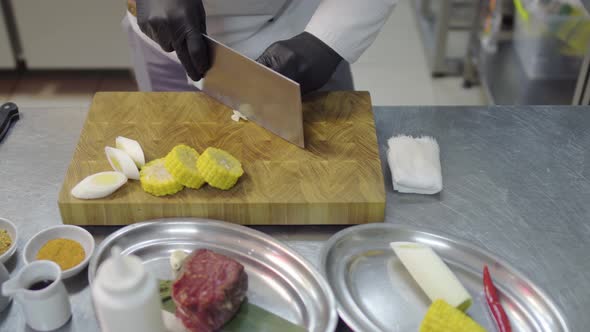 Close Up Hands of a Professional Unrecognized Shuf in Black Gloves Cut Garlic or Onions Into Round alt