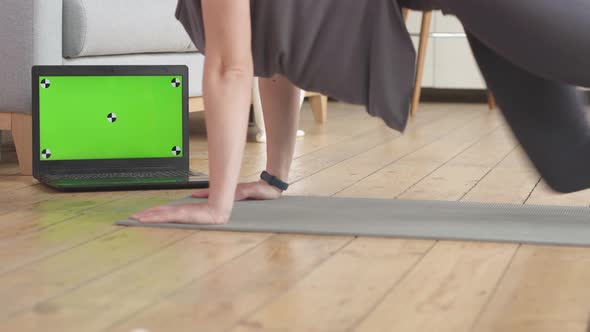 Young Woman Doing the Home Fitness Exercises. Green Screen and Marks on her Laptop.