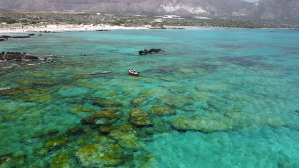 Aerial shot of couple kayaking in turquoise sea during summer day. Travel tropical island holiday co alt
