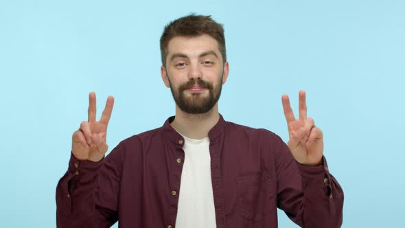 Slow Motion of Handsome and Positive Man with Beard Smiling Friendly Showing Peace Signs and Smiling