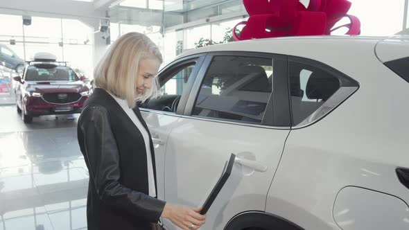 Cheerful Woman Choosing New Car at Dealership Salon