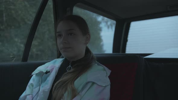 A Modest Young Girl Sits in a Car By the Fire on a Rainy Day and Gives an Interview Into a alt