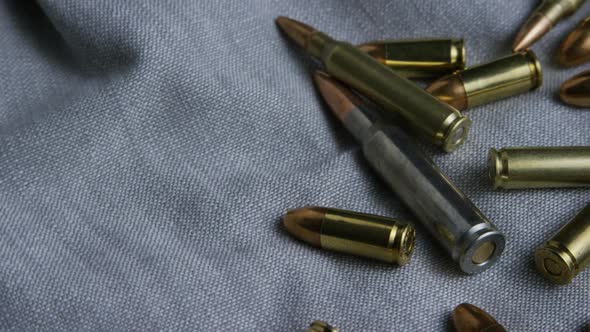 Cinematic rotating shot of bullets on a fabric surface  alt