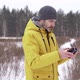 A man in a yellow jacket launches a drone in a field - VideoHive Item for Sale