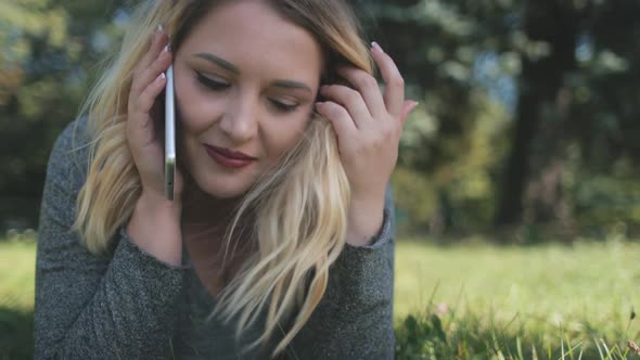 Pretty Girl Smartphone Talk Lie On Green Lawn