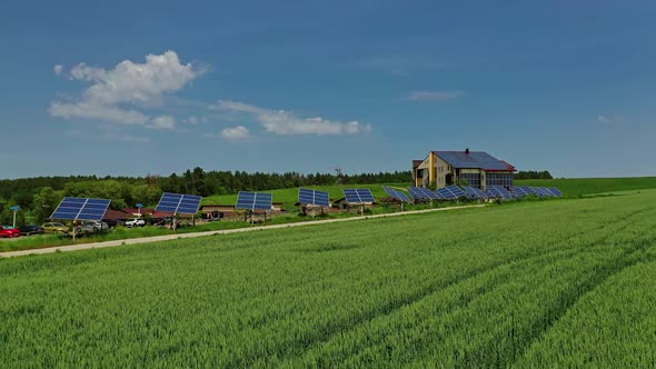 Photovoltaic solar panels on nature background. Blue sunny batteries along the road on green field. alt