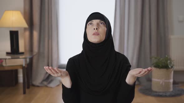 Camera Approaching Slowly To Attractive Muslim Woman in Hijab Praying at Home. Portrait of Young alt