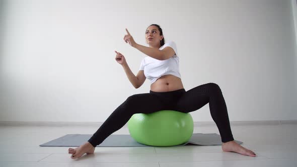 Young Pregnant Woman Goes in for Sports in a Living Room alt