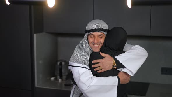 Portrait of Happy Loving Middle Eastern Man in Chequered Keffiyeh Hugging Woman Smiling alt