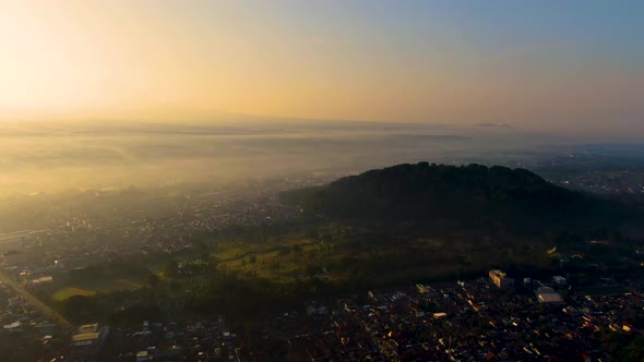 Mount Tidar on picturesque sunrise and Magelang city covered in fog, aerial view alt
