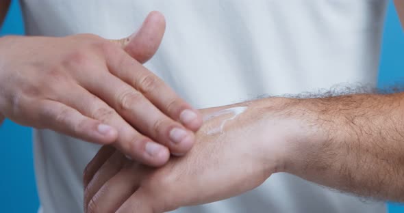 Man Using Cosmetic, Applying Cream on Palms alt